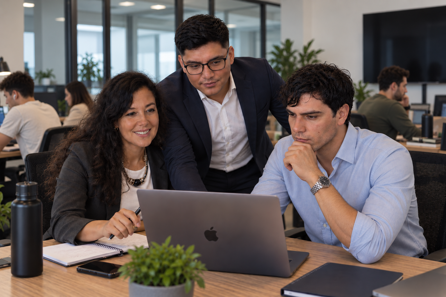 Equipo de Campy colaborando frente a una laptop en la oficina